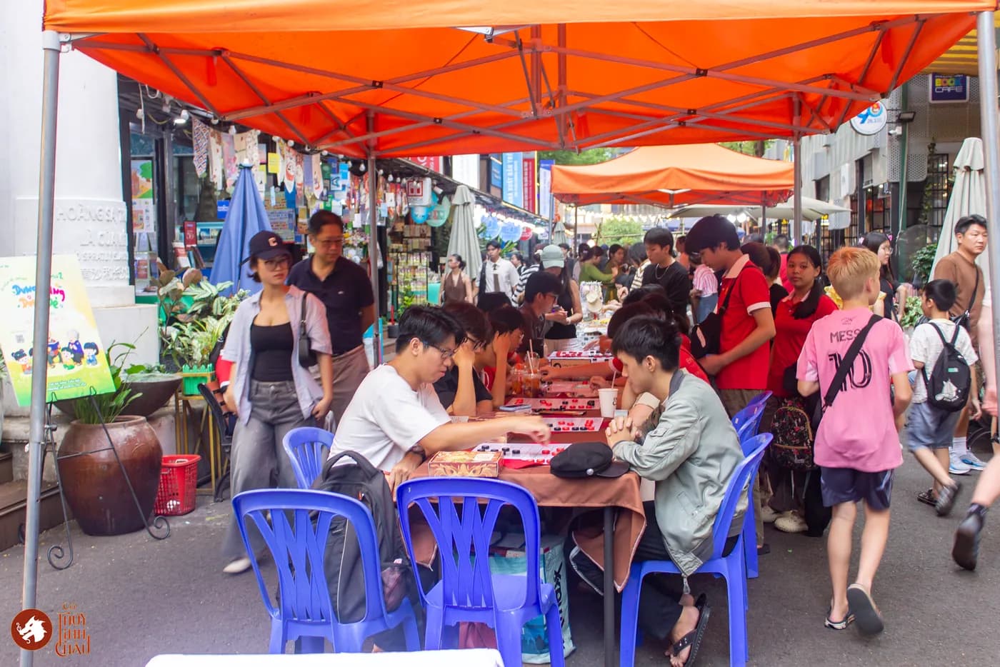 Hình ảnh khách tham dự trải nghiệm Cờ Thủy Tinh châu tại Ngày Hội Sách & Văn hóa Đêm lần 6 với chủ đề "Cầm Kỳ Thư Họa" được tổ chức ở Đường Sách Nguyễn Văn Bình.