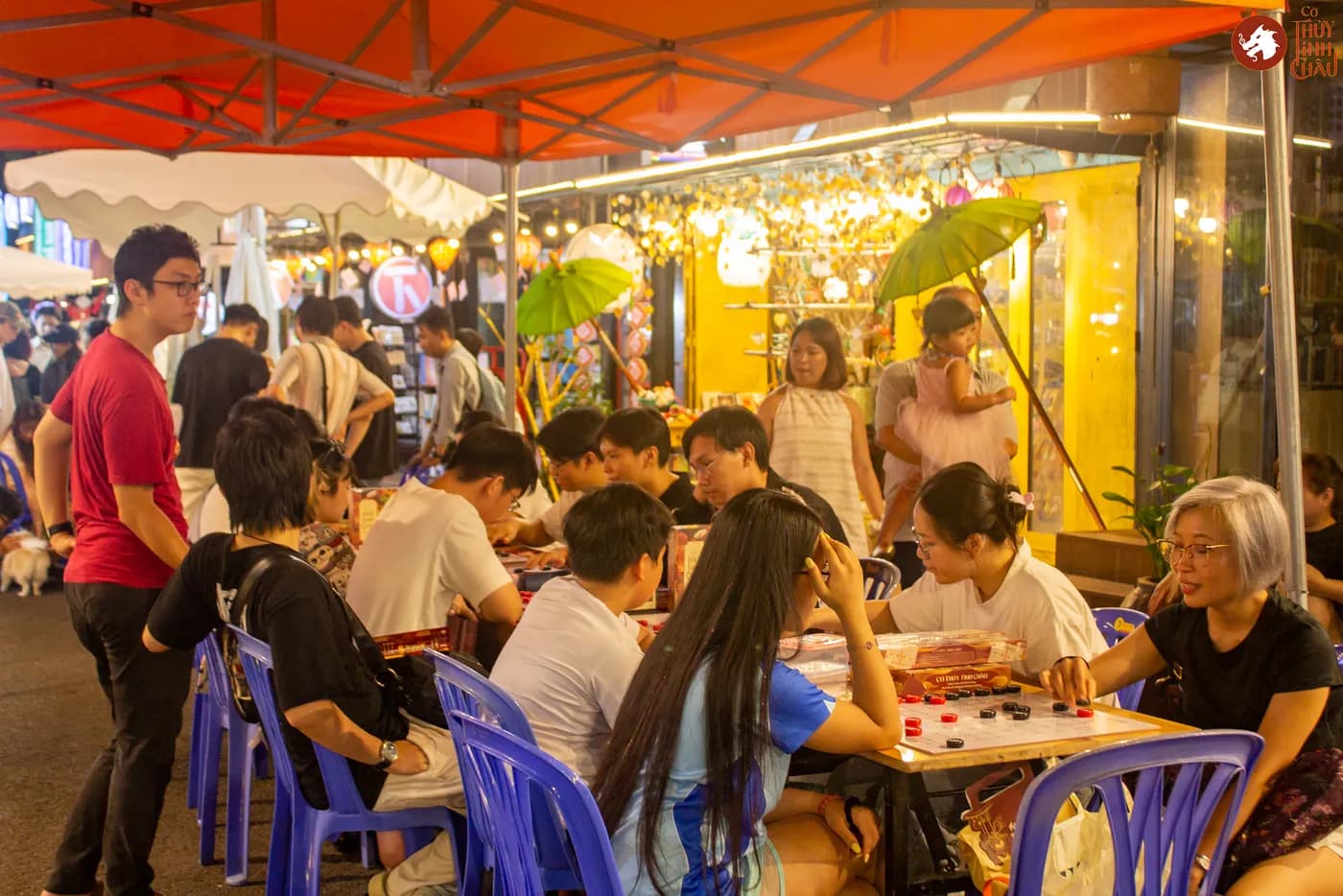 Hình ảnh khách tham dự trải nghiệm Cờ Thủy Tinh châu tại Ngày Hội Sách & Văn hóa Đêm lần 6 với chủ đề "Cầm Kỳ Thư Họa" được tổ chức ở Đường Sách Nguyễn Văn Bình.