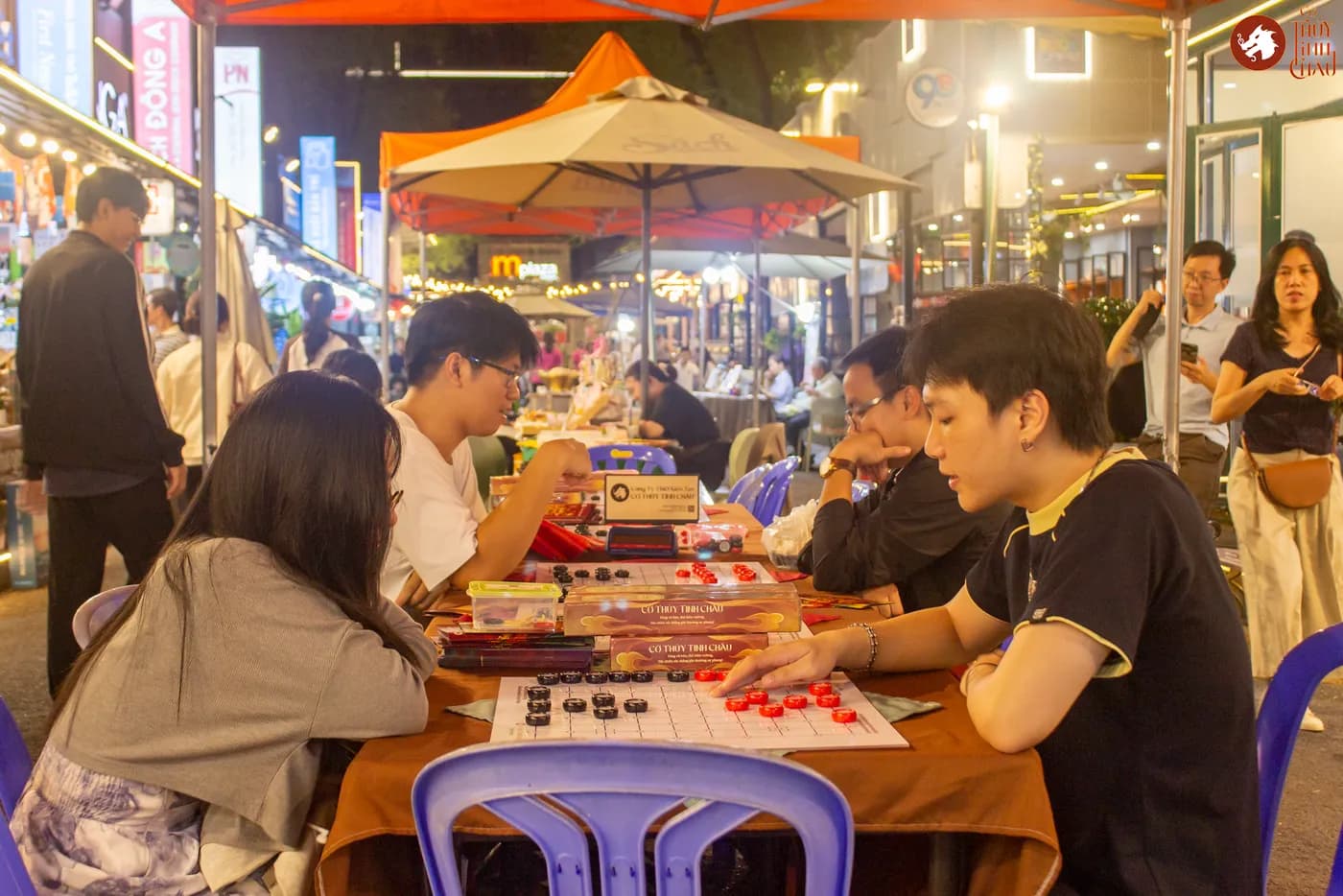 Hình ảnh khách tham dự trải nghiệm Cờ Thủy Tinh châu tại Ngày Hội Sách & Văn hóa Đêm lần 6 với chủ đề "Cầm Kỳ Thư Họa" được tổ chức ở Đường Sách Nguyễn Văn Bình.