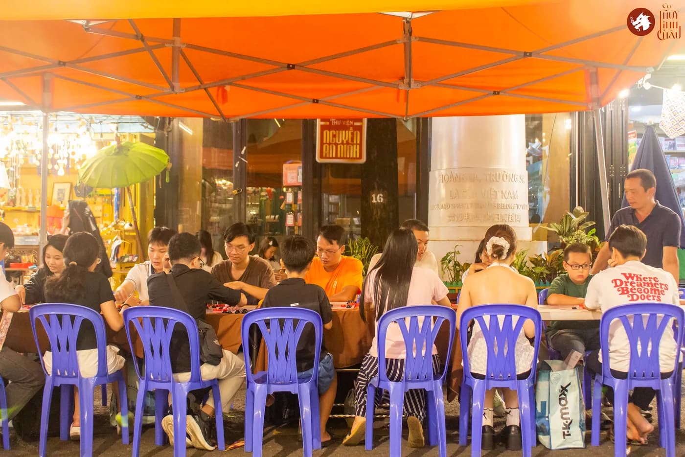 Hình ảnh khách tham dự trải nghiệm Cờ Thủy Tinh châu tại Ngày Hội Sách & Văn hóa Đêm lần 6 với chủ đề "Cầm Kỳ Thư Họa" được tổ chức ở Đường Sách Nguyễn Văn Bình.