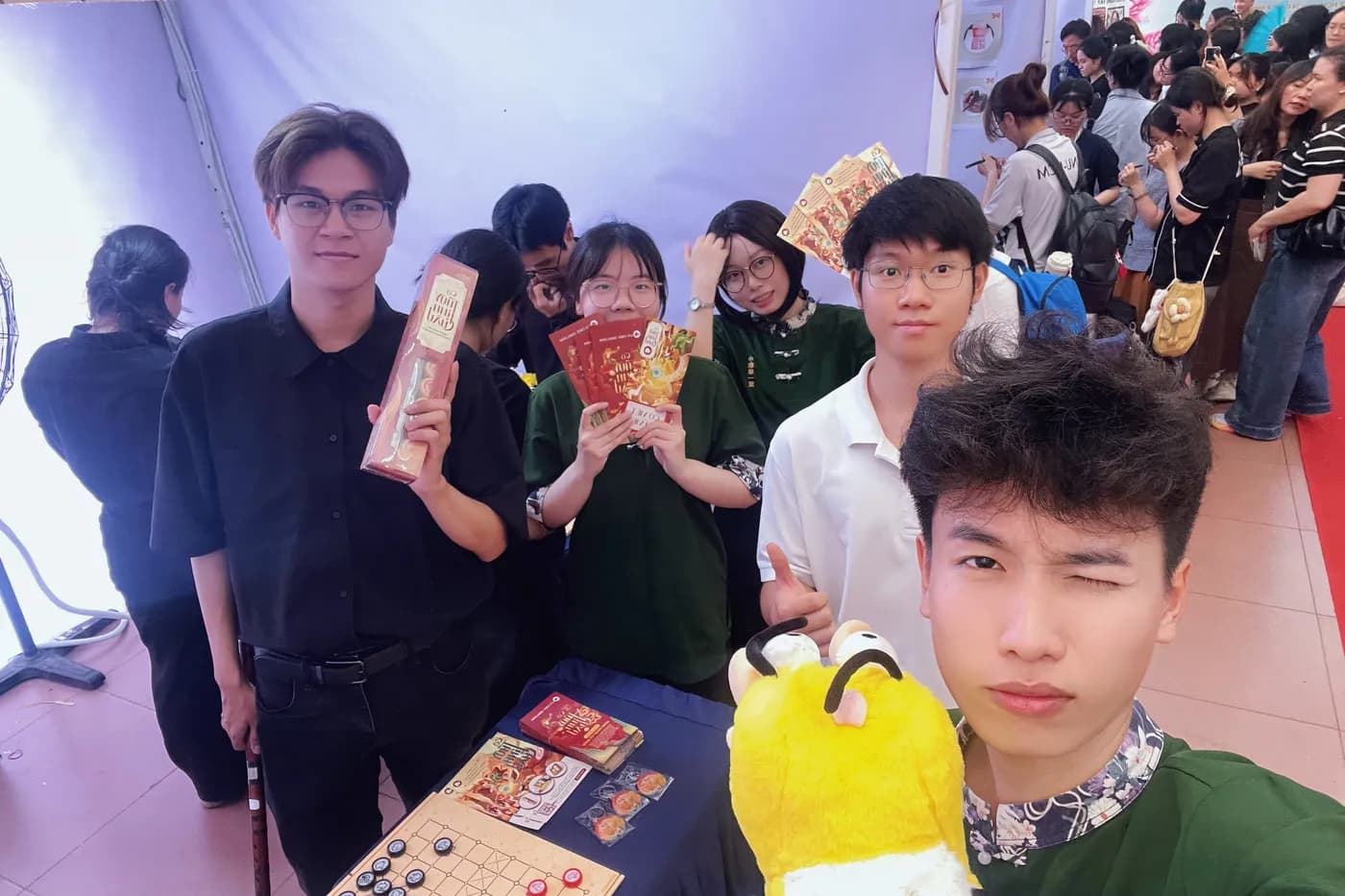 Hình ảnh Team Cờ Thủy Tinh Châu chụp hình cùng các bạn sinh viên tại chương trình "Ngày tiếng Trung Quốc tế 2026" tổ chức ở Đại học Khoa học Xã hội và Nhân văn TPHCM.