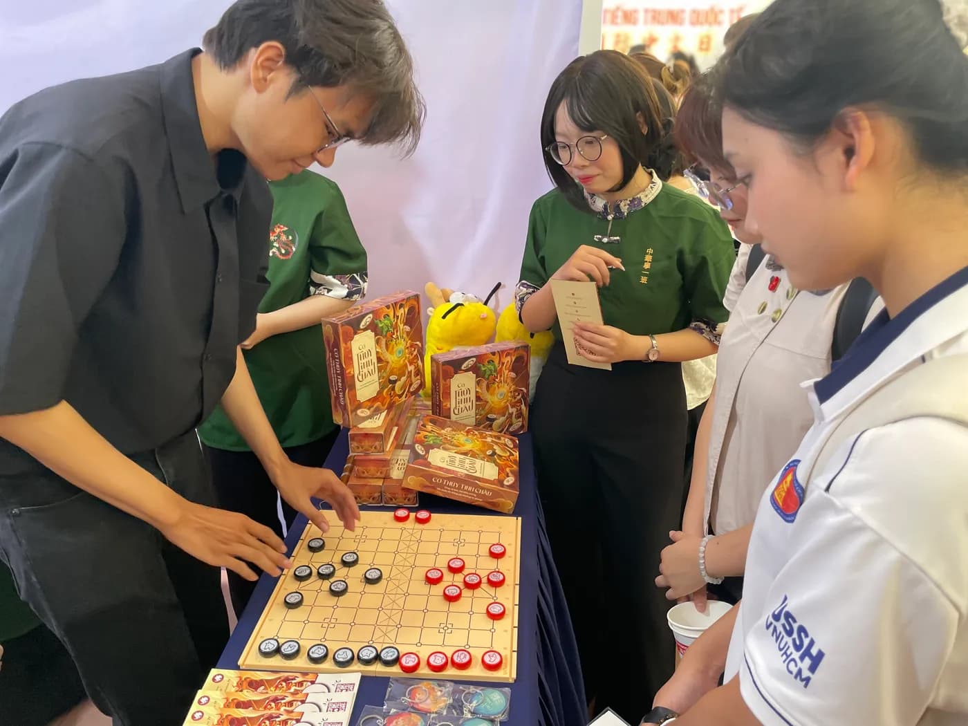 Hình ảnh Team Cờ Thủy Tinh Châu hướng dẫn Cờ 12 con giáp đến các bạn sinh viên tại chương trình "Ngày tiếng Trung Quốc tế 2026" tổ chức ở Đại học Khoa học Xã hội và Nhân văn TPHCM.