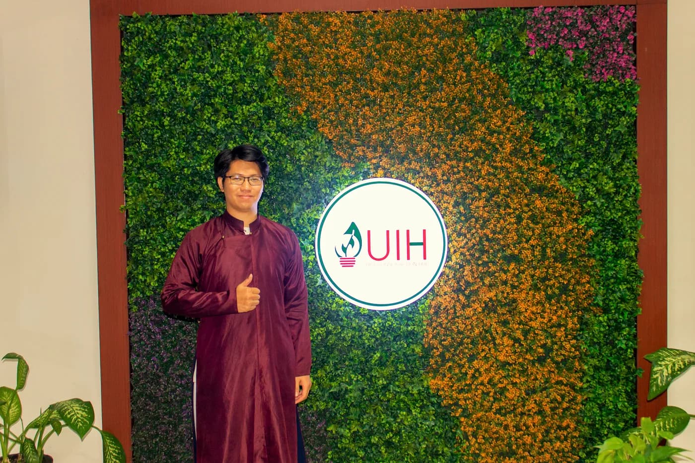 Hình ảnh Co-founder Cờ Thủy Tinh Châu chụp hình cùng logo trường trong chương trình “Chess Meets Destiny – Innovating a 12 Zodiac Board Game for the Startup Era” được tổ chức tại Trường Đại học Surabaya (Indonesia).
