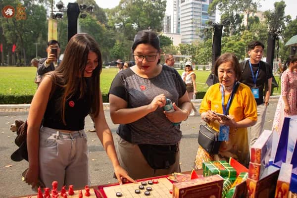 Hình ảnh khách tham dự nước ngoài lần đầu trải nghiệm chơi Cờ Thủy Tinh Châu tại Dinh Độc Lập trong chương trình Họp mặt người Việt Nam ở nước ngoài mừng Xuân Bính Ngọ 2026