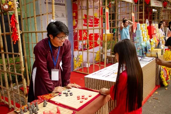 Hình ảnh Team Cờ Thủy Tinh Châu hướng dẫn khách tham dự nhỏ tuổi trải nghiệm Cờ Thủy Tinh Châu tại Dinh Độc Lập trong chương trình Họp mặt người Việt Nam ở nước ngoài mừng Xuân Bính Ngọ 2026