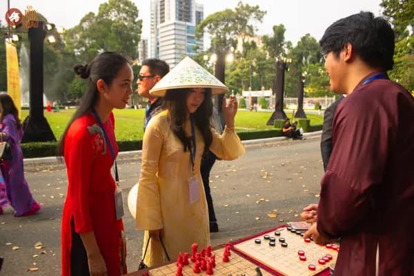 Hình ảnh Team Cờ Thủy Tinh Châu hướng dẫn khách tham dự trải nghiệm Cờ Thủy Tinh Châu tại Dinh Độc Lập trong chương trình Họp mặt người Việt Nam ở nước ngoài mừng Xuân Bính Ngọ 2026