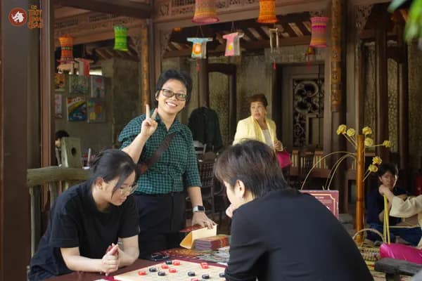 Hình ảnh khách tham dự hứng thú khi được tìm hiểu về Cờ Thủy Tinh Châu tại Bảo tàng Áo dài Việt Nam