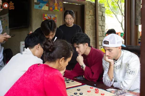 Hình ảnh nhiều tệp khách tham dự như khách Việt, bạn bè quốc tế đang chơi Cờ Thủy Tinh Châu tại sự kiện Bảo tàng Áo dài Việt Nam