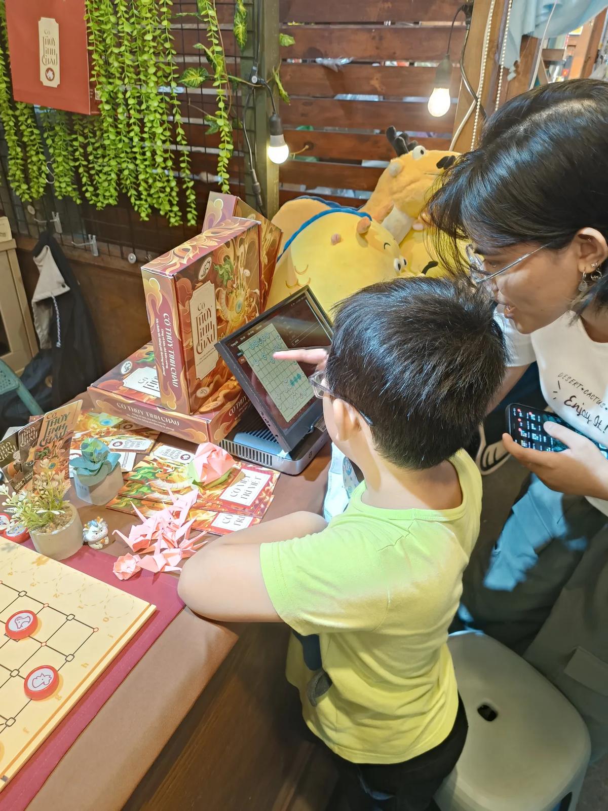 A kid learning chess with Cờ Thủy Tinh Châu at The Box Concept (HCM City Youth Cultural House)