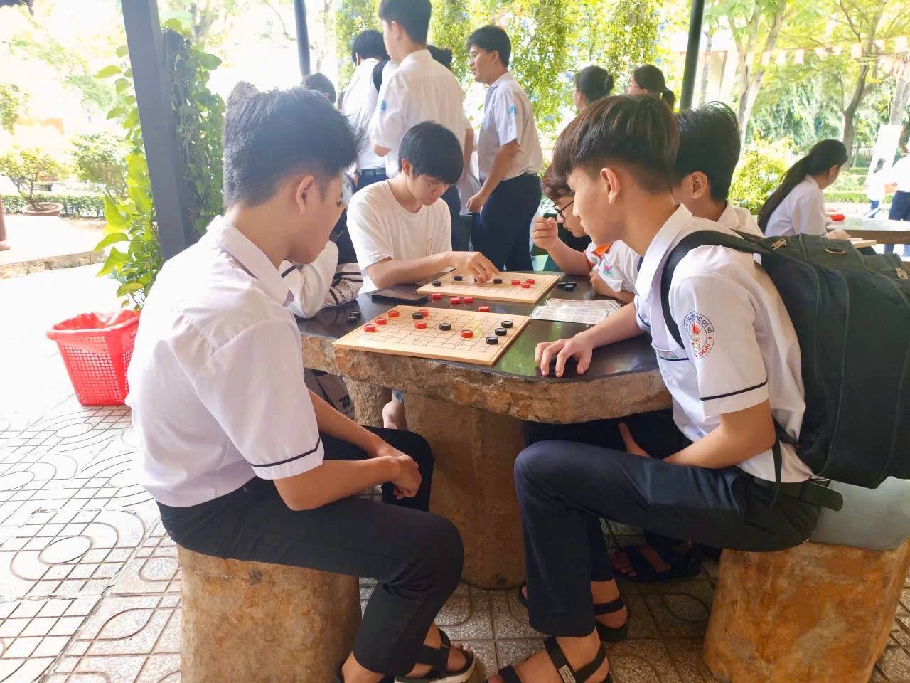 Hình chụp các bạn học sinh/sinh viên chơi Cờ TTC tại Trường DAP trong khuôn khổ Workshop giải đấu Danh Kỳ Lưu Truyền